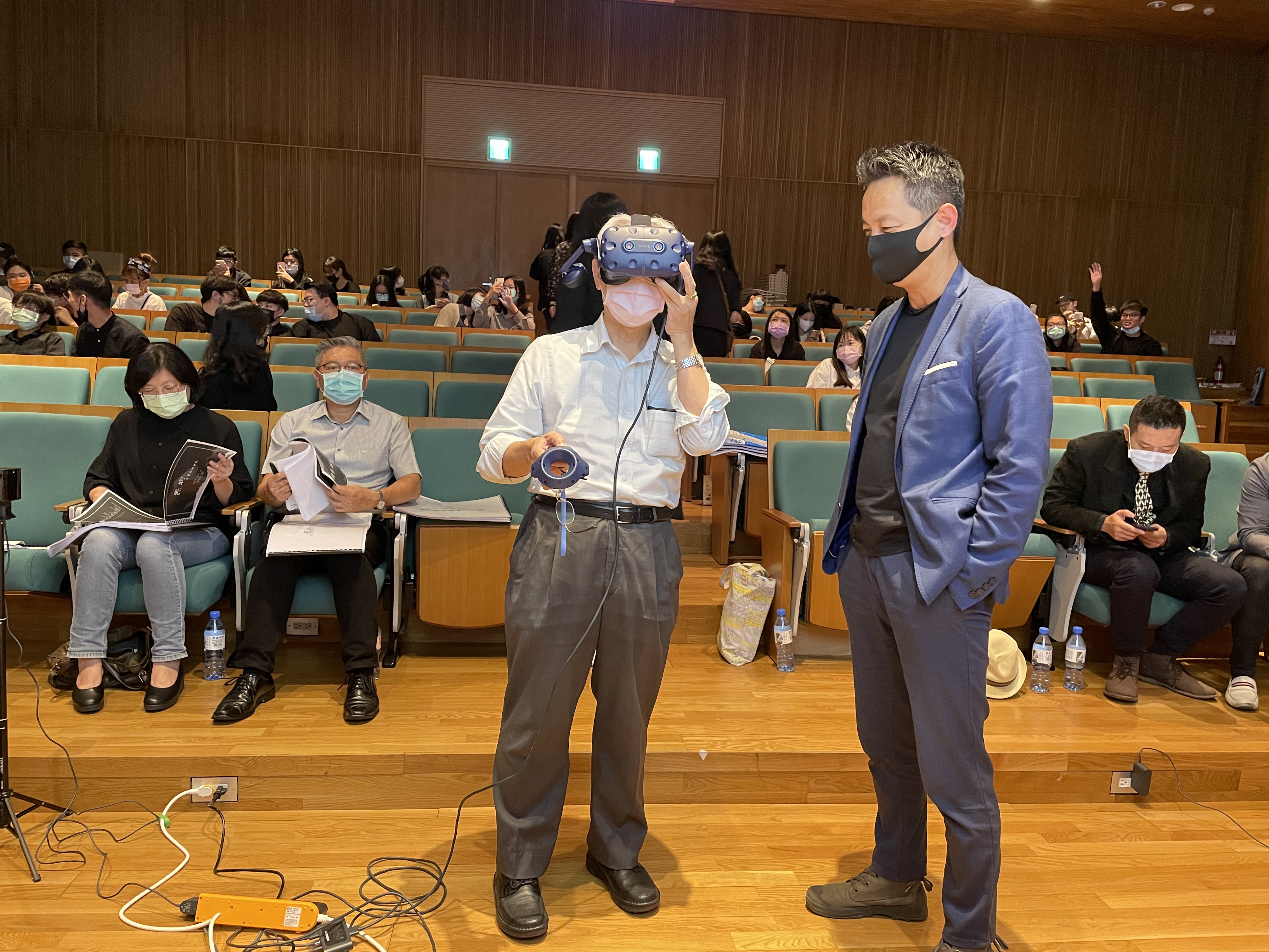 台中科技大學副校長蕭家孟(左)、亞大創意設計院長李元榮(右)，用VR體驗學生作品。