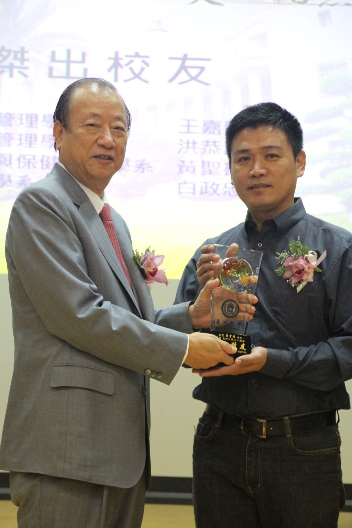 亞大創辦人蔡長海（右）頒發模範校友獎牌，給萬生科技董事長黃聖雄。