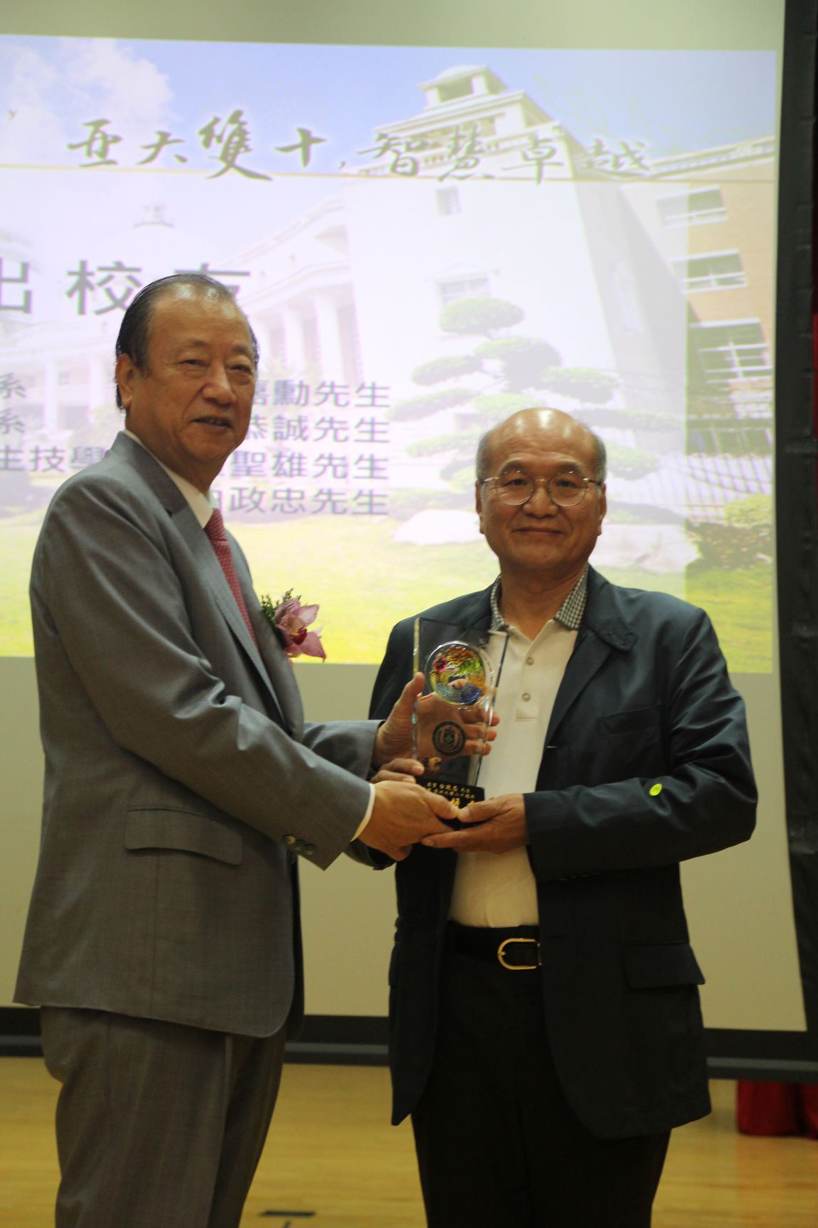 亞大創辦人蔡長海（右）頒發模範校友獎牌，給台萬公司董事長白政忠。