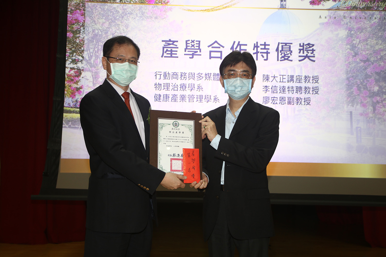 中國醫藥大學副校長郭樹勳（左），頒發「產學合作特優獎」給亞大副校長陳大正